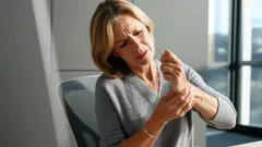 Žena si drží bolestivé zápästie, príznak bolesti kĺbov alebo artritídy