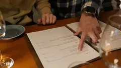 Ľudia si prezerajú jedálny lístok v reštaurácii, výber jedla pri stole.
