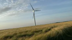 Veterná elektráreň na poli za slnečného dňa