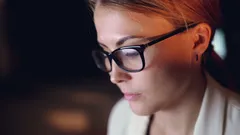Mladá podnikateľka pracujúca večer s odrazom obrazovky v okuliaroch