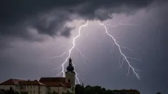 Blesk udiera do kostola počas búrky, tmavé mraky na oblohe, nočná scéna